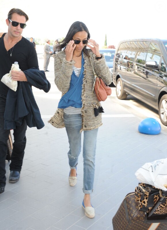 L'actrice Zoe Saldana arbore un look de ville lors de ses voyages, et n'oublie pas les lunettes de soleil (des Ray-Ban Clubmaster) pour cacher des yeux fatigués. Aéroport de Nice, le 20 mai 2011.