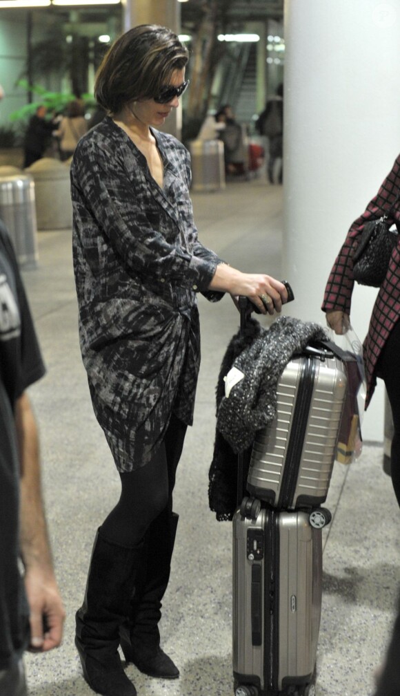 L'actrice Milla Jovovich, détendue à l'aéroport de Los Angeles, avec ses valises Rimowa. 31 mars 2011.