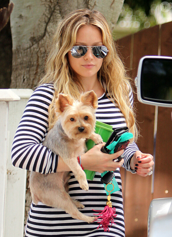 Hilary Duff à Los Angeles, vendredi 26 août 2011, planquée derrière ses  lunettes fumées, regagnant son domicile en compagnie de son petit  yorkshire.
