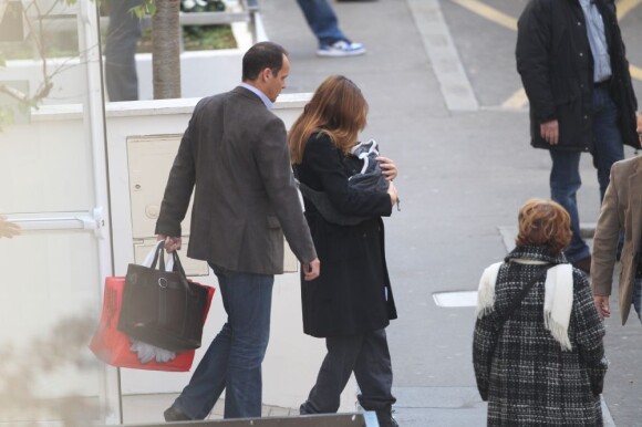 Carla Bruni quitte la clinique de la Muette à Paris, le 23 octobre 2011, avec sa petite Giulia dans les bras.