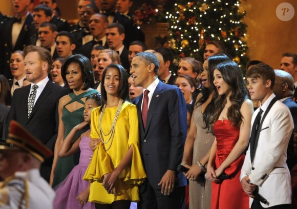 La famille Obama, entourée de (de g. à d.) Conan O'brien, Jennifer Hudson, Victoria Justice et Justin Bieber, entonnent un dernier chant de Noël après le gala Christmas in Washington. Le 11 décembre 2011.
