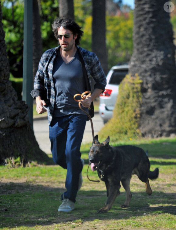 Ben Affleck, derrière ses lunettes de soleil, se balade avec son chien, le 2 janvier 2012 à Los Angeles