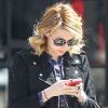 L'actrice Emma Roberts, focalisée sur son iPhone, porte ici un perfecto en daim sur une chemise, un slim taille haute, des bottines Isabel Marant et un mini luggage Céline. New York, le 27 mars 2012.