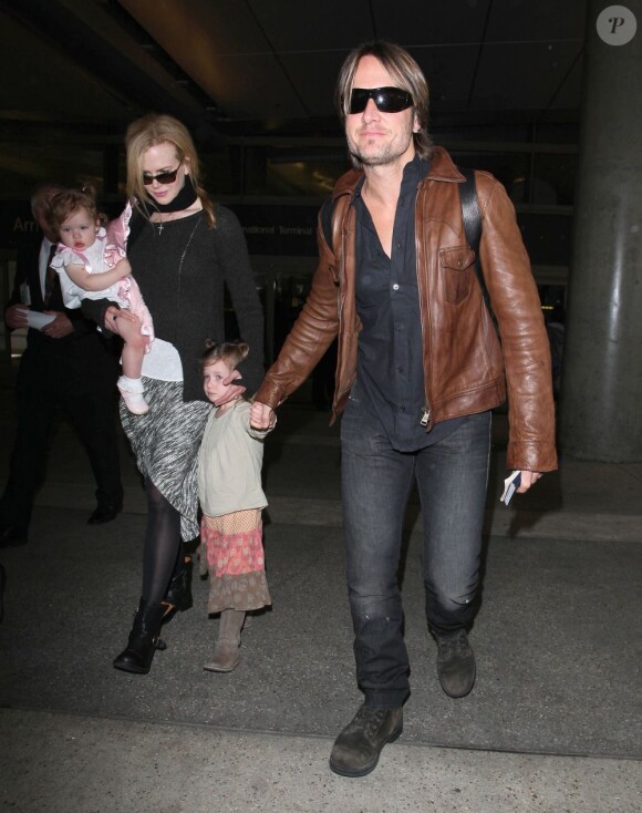 Fatigués mais souriants, Nicole Kidman et son mari Keith Urban sortent de l'aéroport de Los Angeles avec leurs filles le 29 mars 2012