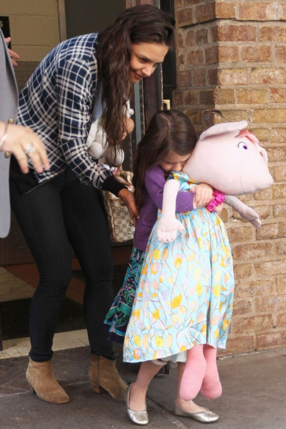 Katie Holmes encourage sa fille qui porte une peluche aussi grande qu'elle. A New York, le 27 avril 2012.