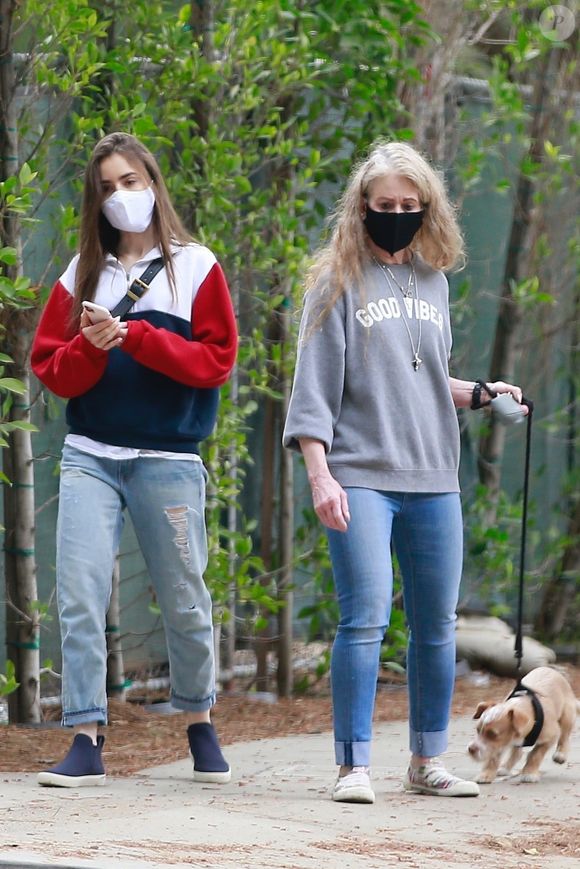 Lily Collins et sa mère Jill Tavelman, équipées de masques, promènent leur chien à Beverly Hills pendant l'épidémie de coronavirus (Covid-19), le 29 avril 2020. Jill Tavelman, 64 ans, a été mariée au chanteur P. Collins de 1984 à 1996.