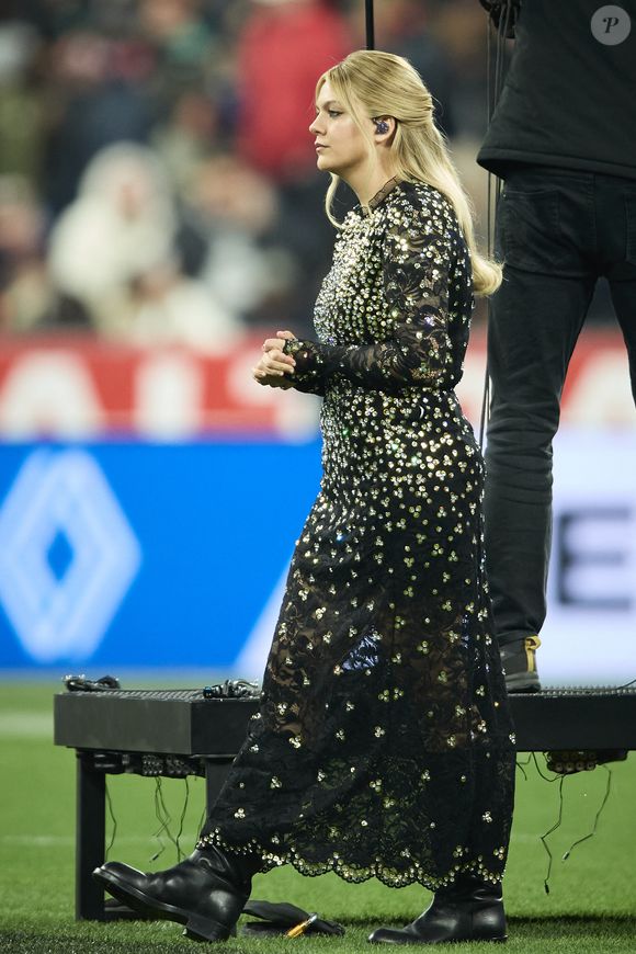 La chanteuse Louane (Louane Emera), représentante de la France au concours de l'Eurovision, interpréte pour la première fois son titre Maman, en hommage à sa mère décédée lorsqu'elle avait 17 ans, devant les 80 000 spectateurs, suspendue sur une plateforme, plusieurs mètres au-dessus de la pelouse et des musiciens, du Stade de France à la mi-temps du match du Tournoi des Six Nations opposant la France à l'Écosse, à Saint-Denis, Seine Saint-Denis, France, le 15 mars 2025. © Cyril Moreau/Bestimage