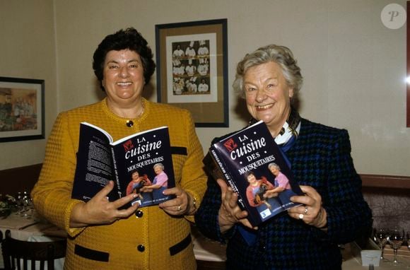 En France, à Paris, dans le restaurant La Regalade, dans le XIVeme arrondissement, de gauche à droite, MAITE, de son vrai nom Marie-Thérèse Ordonez et Micheline Banzet-Lawton posant et présentant  leur livre, le deuxieme tome de LA CUISINE DES MOUSQUETAIRES le 7 décembre 1993.