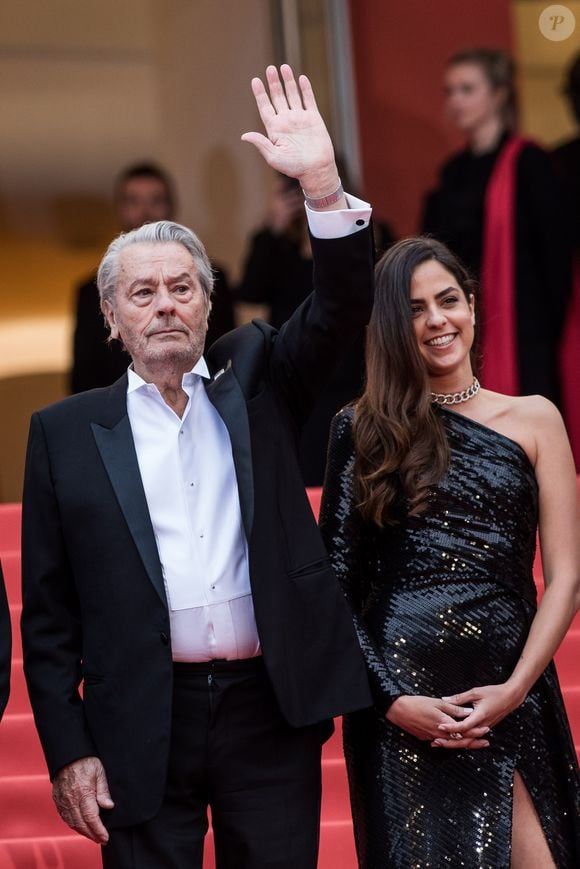 Alain Delon (avec un badge Paris Match d'une ancienne couverture du magazine titrant "Alain Delon, mes deux amours, Rosalie et Anouchka) et sa fille Anouchka Delon - Montée des marches du film "A Hidden Life" lors du 72ème Festival International du Film de Cannes. Le 19 mai 2019 © Jacovides-Moreau / Bestimage
