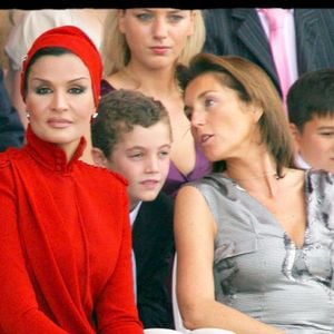 En rallongeant les coupes, en couvrant les bras ou en doublant des éléments transparents, elle transforme ces silhouettes de défilés en pièces strictement uniques. 

Cécilia Sarkozy et la femme de l'émir du Qatar, Cheikh Hamad ben Khalifa Al Thani. Derrière : Jeanne-Marie Martin et Louis Sarkozy – tribunes – défilé du 14 Juillet sur les Champs-Élysées. ALAIN GUIZARD / BESTIMAGE