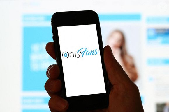 Un homme consulte le site Internet d'OnlyFans sur un ordinateur et un téléphone portable Photo by Alamy/ABACAPRESS.COM