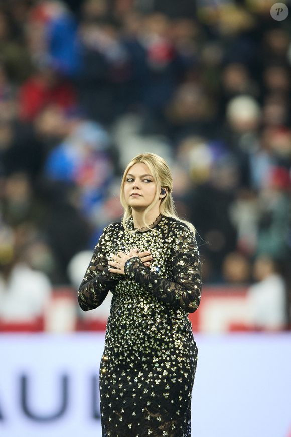 La chanteuse Louane (Louane Emera), représentante de la France au concours de l'Eurovision, interpréte pour la première fois son titre Maman, en hommage à sa mère décédée lorsqu'elle avait 17 ans, devant les 80 000 spectateurs, suspendue sur une plateforme, plusieurs mètres au-dessus de la pelouse et des musiciens, du Stade de France à la mi-temps du match du Tournoi des Six Nations opposant la France à l'Écosse, à Saint-Denis, Seine Saint-Denis, France, le 15 mars 2025. © Cyril Moreau/Bestimage
