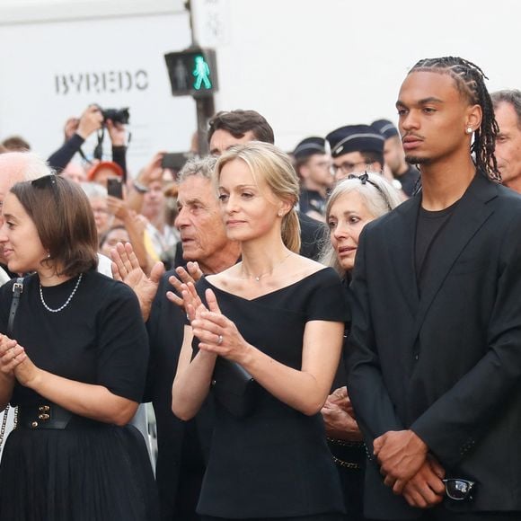 Costume noir et lunettes sombres : le “dress code Ardisson” a été scrupuleusement respecté par les invités, dans un clin d’œil assumé au style légendaire de l’animateur.

Manon Ardisson, Ninon Ardisson, Patrick Ardisson, Audrey Crespo-Mara et son fils Zekou, Gaston Ardisson - Sorties des obsèques de Thierry Ardisson en l’église Saint-Roch de Paris, France, le 17 juillet 2025. © Clovis-Jacovides/Bestimage