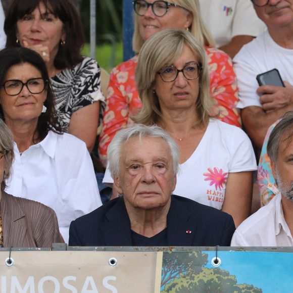 Semi-exclusif - Michel Sardou et sa femme Anne-Marie Périer, Romain Sardou - Michel Sardou rend hommage à son père en famille lors du premier trophée de pétanque "Fernand Sardou" à Bormes-les-Mimosas le 29 mai 2026. Le célèbre chanteur est venu en famille avec sa femme, son fils Romain avec son fils de deux ans et demi et de sa compagne enceinte de son deuxième enfant.
La première édition du Trophée Fernand Sardou est organisée du 29 au 31 mai au coeur du village de Bormes les Mimosas. Une initiative portée par Michel et son fils Romain, pour rendre hommage à leur illustre parent Fernand Sardou au travers d'un tournoi de pétanque.
En lien avec la municipalité et l'Amicale Bouliste Borméenne (ABB), un premier Trophée Fernand Sardou sera organisé avec deux grands temps forts : Le vendredi, dès 18h, un tournoi d'exhibition sera proposé et verra s'affronter 16 triplettes. Puis un concours fédéral à pétanque sera organisé le weekend et ouvert à tous les amateurs. 128 équipes seront réparties sur les sites les plus emblématiques du village, à savoir au boulodrome de la place Saint-François, mais aussi au parc Cigalou, sur le site du château et à l'ancien stade. © Franz Chavaroche/Bestimage