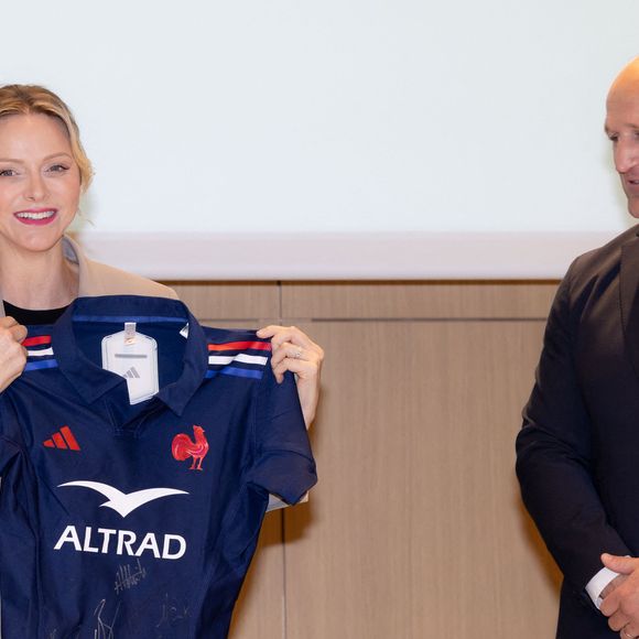 La princesse Charlène de Monaco se voit offrir un maillot dédicacé par les joueurs du XV de France de rugby, vainqueurs du tournoi des 6 nations 2025, des mains de William Servat, l'entraîneur du XV de France - La princesse C.de Monaco, en compagnie de son frère G.Wittstock, participe à la remise des prix de la "Journée du respect" au collège Charles III à Monaco, le 29 avril 2025. © Olivier Huitel / Pool Monaco / Bestimage