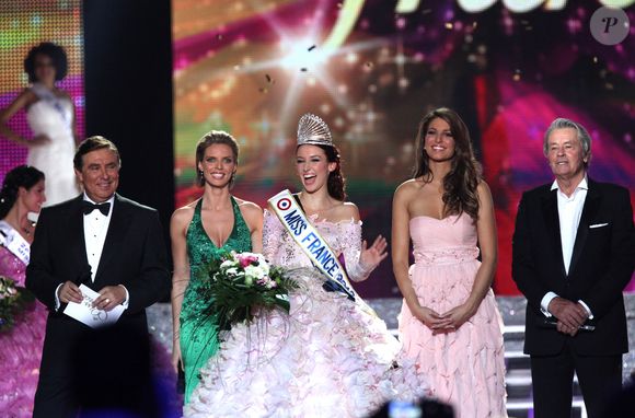 Il n'est plus, notamment, question que les Miss se livrent à des bains de foule sans qu'elle ne soit protégée. La direction du concours a "pris des mesures pour éloigner les participantes, et notamment les Miss France, du public", a détaillé Gilles Verdez, sur W9, relatant des informations du "Parisien".

Laury Thilleman (Miss France 2011), Delphine Wespiser, Sylvie Tellier, Alain Delon et Jean-Pierre Foucault - Delphine Wespiser devient la nouvelle Miss France, en 2011, à Brest. AGENCE / BESTIMAGE