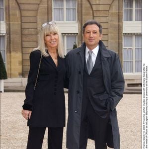 Le présentateur de télévision Michel Drucker pose avec son épouse Dany Saval après avoir reçu des mains du Président Jacques Chirac la médaille d'Officier de la Légion d'Honneur lors d'une cérémonie au Palais de l'Elysée le 15 mars 2004. © Serge Arnal/ABACA.