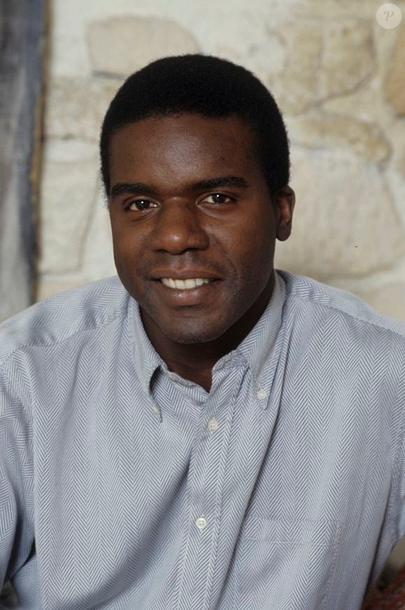 Exclusif - Archives - No web - En France, portrait en intérieur de Jacques MARTIAL, assis devant un mur de pierre, vêtu d'une chemise bleue, souriant. 1990
© Michel Croizard via Bestimage