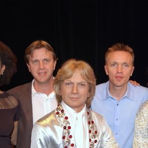 Les fils de Claude François, Claude Jr et Marc (chemise bleue), ainsi que les Clodettes, anciennes danseuses, inaugurent le double de cire de Claude François (décédé en 1978) au musée Grévin à Paris, le 20 juin 2004. Photo par Bruno Klein/ABACA.