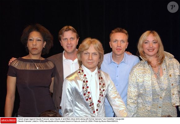 Les fils de Claude François, Claude Jr et Marc (chemise bleue), ainsi que les Clodettes, anciennes danseuses, inaugurent le double de cire de Claude François (décédé en 1978) au musée Grévin à Paris, le 20 juin 2004. Photo par Bruno Klein/ABACA.