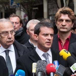 Le ministre de l'Intérieur Manuel Valls s'adresse à la presse en compagnie du directeur de Libération Fabrice Rousselot (au centre, chemise rouge), du président de Libération Nicolas Demorand (à droite) et du maire de Paris Bertrand Delanoë (à gauche) devant le siège du quotidien français Libération, le 18 novembre 2013 à Paris, France. Un tireur a ouvert le feu dans le hall du bâtiment, blessant un photographe débutant. Photo par Romain Boe/ABACAPRESS.COM