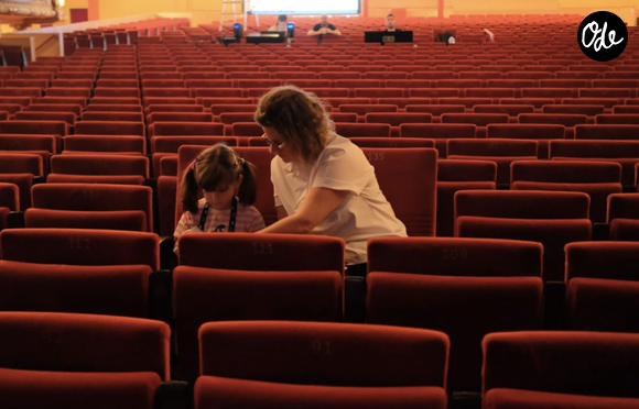 “Joyeux anniversaire mon amour de ma vie”, écrit-elle d’abord écrit. Elle poursuit : “Je traverserais à nouveau toutes les galères de ma vie, toutes les peines si je savais qu’au bout du chemin, ça me ramènerait à toi.”

Elodie Poux pose avec sa fille dans une salle de spectacle. Photo postée sur Instagram le 11 octobre 2026