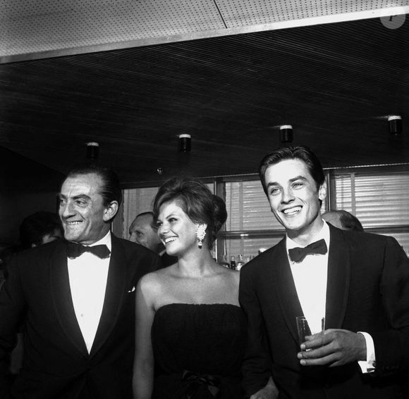 Luchino Visconti, Claudia Cardinale et Alain Delon à la fête sur l'Ausonia pour la présentation du film 'Rocco e i suoi fratelli', 21ème Festival du Film de Venise (1961). Photo by Alamy/ABACAPRESS.COM