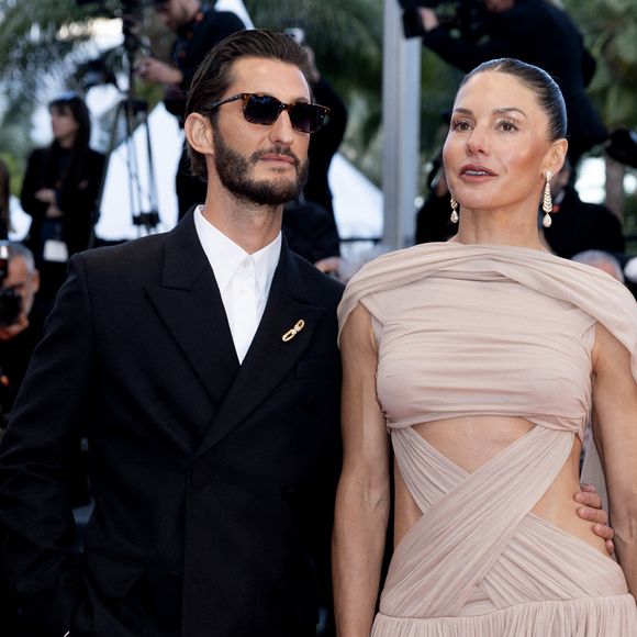 Pour l'occasion, l'acteur est apparu en costume noir et sa compagne en robe drapée nude.

Pierre Niney et sa compagne Natasha Andrews - Montée des marches du film " Histoires parallèles " lors du 79ème Festival International du Film de Cannes, le 14 mai 2026. © Olivier Borde / Bestimage
