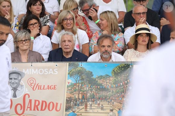 Semi-exclusif - Michel Sardou et sa femme Anne-Marie Périer, Romain Sardou et sa compagne Kym Thiriot enceinte - Michel Sardou rend hommage à son père en famille lors du premier trophée de pétanque "Fernand Sardou" à Bormes-les-Mimosas le 29 mai 2026. Le célèbre chanteur est venu en famille avec sa femme, son fils Romain avec son fils de deux ans et demi et de sa compagne enceinte de son deuxième enfant.
La première édition du Trophée Fernand Sardou est organisée du 29 au 31 mai au coeur du village de Bormes les Mimosas. Une initiative portée par Michel et son fils Romain, pour rendre hommage à leur illustre parent Fernand Sardou au travers d'un tournoi de pétanque.
En lien avec la municipalité et l'Amicale Bouliste Borméenne (ABB), un premier Trophée Fernand Sardou sera organisé avec deux grands temps forts : Le vendredi, dès 18h, un tournoi d'exhibition sera proposé et verra s'affronter 16 triplettes. Puis un concours fédéral à pétanque sera organisé le weekend et ouvert à tous les amateurs. 128 équipes seront réparties sur les sites les plus emblématiques du village, à savoir au boulodrome de la place Saint-François, mais aussi au parc Cigalou, sur le site du château et à l'ancien stade. © Franz Chavaroche/Bestimage