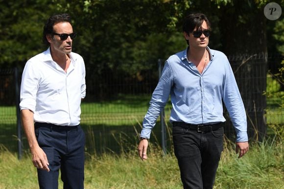 Anthony Delon et son demi-frère Alain-Fabien découvrent les hommages devant les grilles de la propriété de Douchy, quelques heures avant les obsèques de leur père, A.Delon, le 24 août 2024. © Agence / Bestimage