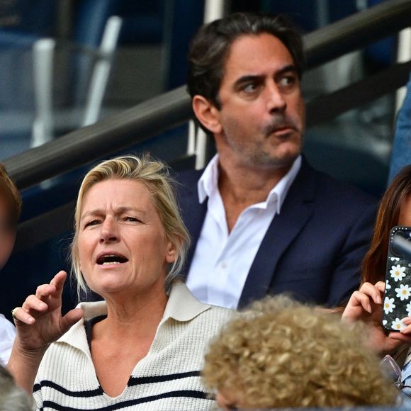 Anne-Elisabeth Lemoine, Sylvie Tellier et son mari Laurent Schenten - Célébrités dans les tribunes du match de football de Ligue 1 McDonald's opposant le  RC Lens au Paris Saint-Germain (PSG) (0-2) au Parc des Princes à Paris le 14 septembre 2025. © Christian Liewig/Bestimage