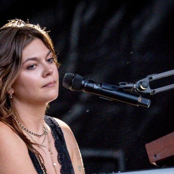 Sur le cliché en noir et blanc, on découvre la chanteuse de dos - facilement reconnaissable à ses célèbres tatouages qui ornent son bras gauche - lovée dans une robe ultra-glamour.

Louane se produit sur la scène du festival "Printemps de Pérouges" au château de Saint-Maurice-de-Rémens (01 - France) le 28/06/2026. © Sandrine Thesillat/Psnewz/Bestimage