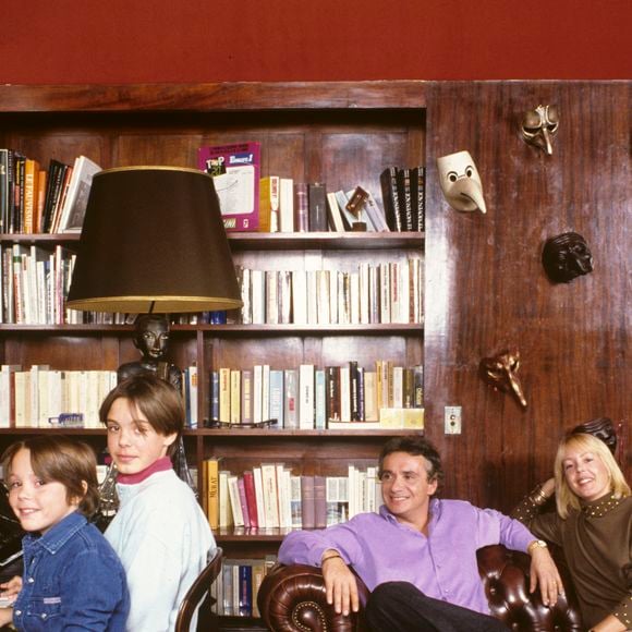 L'intérieur se distingue par une décoration élégante aux tons bruns et une immense baie vitrée ouverte sur la verdure.

Archives - En France, à Paris, rendez-vous avec Michel Sardou, à son domicile, avec ses 2 fils, Romain, 13 ans et Davy, 9 ans, dans le salon, avec sa femme Babette. Novembre 1987
© Michel Marizy via Bestimage