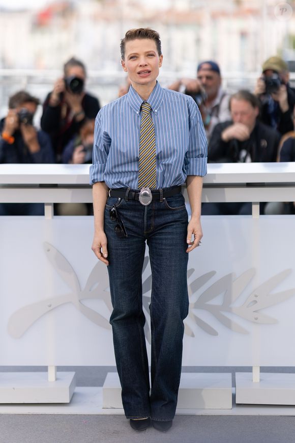 Elle arborait une chemise bleue à fines rayures blanches, manches retroussées et sagement boutonnée jusqu'au col, habillée d'une cravate à rayures diagonales jaunes et sombres. 

Mélanie Thierry au photocall du film "La Vie D'Une Femme" lors du 79ème Festival International du Film de Cannes, France, le 14 mai 2026. © Jacovides-Moreau/Bestimage