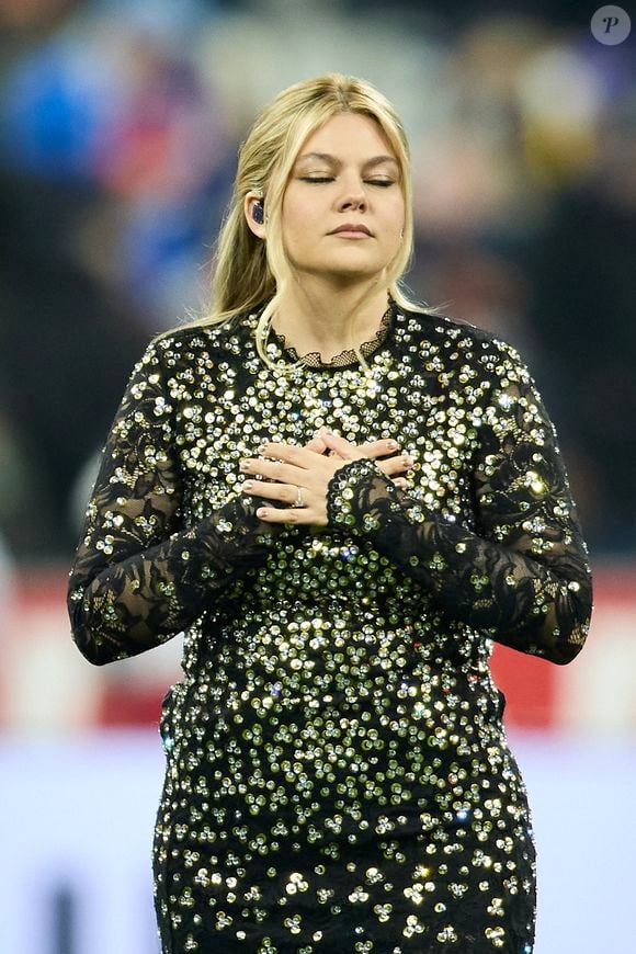 La chanteuse Louane (Louane Emera), représentante de la France au concours de l'Eurovision, interpréte pour la première fois son titre Maman, en hommage à sa mère décédée lorsqu'elle avait 17 ans, devant les 80 000 spectateurs, suspendue sur une plateforme, plusieurs mètres au-dessus de la pelouse et des musiciens, du Stade de France à la mi-temps du match du Tournoi des Six Nations opposant la France à l'Écosse, à Saint-Denis, Seine Saint-Denis, France, le 15 mars 2025. © Cyril Moreau/Bestimage