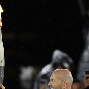PARIS, le 26 juillet 2024 - L'ancien footballeur français Zinedine Zidane porte la flamme olympique au stade du Trocadéro lors de la cérémonie d'ouverture des Jeux Olympiques de Paris 2024 à Paris, en France, le 26 juillet 2024. Photo : Xinhua/ABACAPRESS.COM/Li Ying)