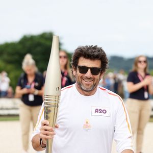 Le chanteur et acteur Patrick Bruel porteur de la flamme olympique des Jeux Olympiques de Paris 2024 (JO) au château de Versailles dans les Yvelines, France, le 23 juillet 2024. © Dominique Jacovides/Bestimage
