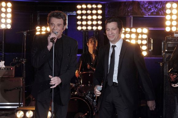 "Je redoute particulièrement les coups de fil nocturnes de Johnny. Parfois, vers 4 heures du matin, ma femme Dany, sa copine depuis les années 1960, me réveille en me tendant le combiné. Johnny commence toujours par les même mots (...) 'Tu diras à cet en**lé de Gerra que, s'il continue à me faire passer pour un con, je vais lui péter la gueule.'", écrivait l'animateur.

Laurent Gerra et Johnny Hallyday - Emission "Laurent Gerra ne s'interdit rien" diffusée sur TF1 le 10 décembre 2011.
AGENCE / BESTIMAGE
