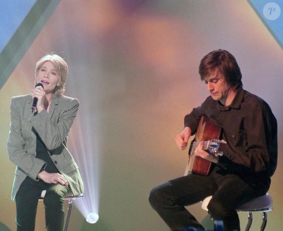 En France, à Paris, sur le plateau de l'émission "MTV'S French Link", Françoise Hardy accompagnée à la guitare par son fils Thomas Dutronc.