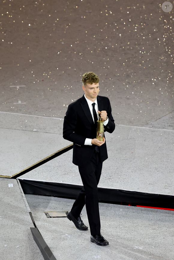 Léon Marchand s'apprête à remettre la flamme olympique à T.Bach, président du CIO, sous le regard de T.Riner et d'autres athlètes - Cérémonie de clôture des Jeux Olympiques de Paris 2024 au stade de France à Saint-Denis, le 11 août 2024. 
© Jacovides-Perusseau / Bestimage