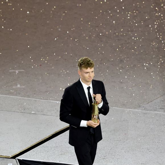Léon Marchand s'apprête à remettre la flamme olympique à T.Bach, président du CIO, sous le regard de T.Riner et d'autres athlètes - Cérémonie de clôture des Jeux Olympiques de Paris 2024 au stade de France à Saint-Denis, le 11 août 2024. 
© Jacovides-Perusseau / Bestimage