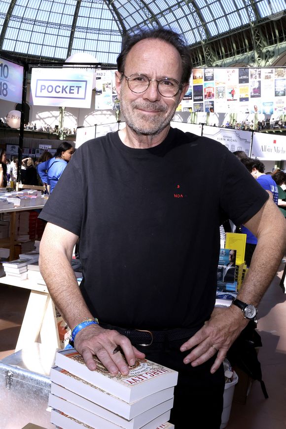 À l'intérieur, l'ambiance est cosy et personnelle. Les étagères croulent sous les livres et les objets chinés au fil de ses tournées mondiales. 

Marc Levy - Festival du Livre de Paris 2025 au Grand Palais à Paris le 11 avril 2025.

© Cédric Perrin / Bestimage