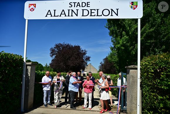 Le stade municipal a été rebaptisé "Stade Alain Delon", en présence d’élus locaux et de journalistes plus nombreux que les admirateurs. 

Une cérémonie en hommage à Alain Delon a été organisée un an jour pour jour après la mort de l'acteur, à Douchy-Montcorbon (Loiret), France, le 18 août 2025, commune où la star a vécu durant plusieurs décennies, une plaque a été dévoilée à l'intérieur du stade en honneur de l'acteur, qui avait équipé en 1983 les équipes de football de jeunes de Douchy de maillots à son nom et une projection d'un film documentaire de 45 mn "Delon-Douchy", écrit autour de la relation entre l'acteur et la commune, est aussi programmée en début de soirée dans la salle des fêtes communale. © Christian Liewig/Bestimage