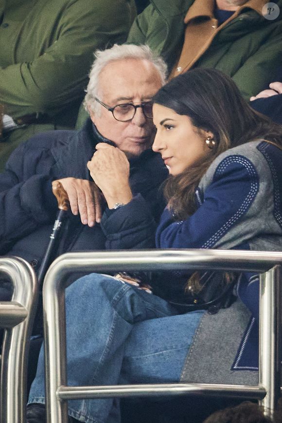 Daniel Hechter et une amie - Célébrités dans les tribunes lors du match de Ligue 1 McDonald's opposant le Paris Saint-Germain (PSG) à l'Olympique de Marseille (OM) - (3-1) au Parc des Princes à Paris le 16 mars 2025. © Cyril Moreau/Bestimage