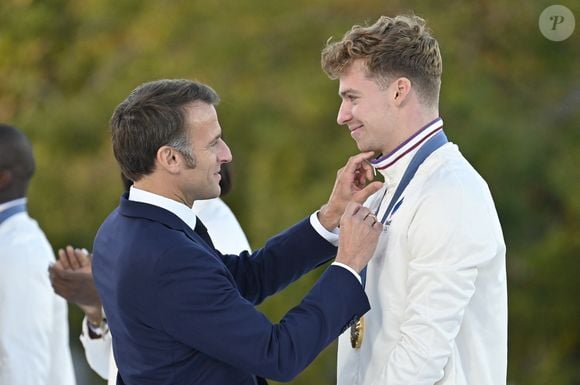 Emmanuel Macron, président de la République Française et Léon Marchand lors de la Parade des Champions des Jeux Olympiques et Paralympiques de Paris 2024, sur les Champs-Elysées. Paris, le 14 septembre 2024.

© Eric Tschaen/Pool/Bestimage