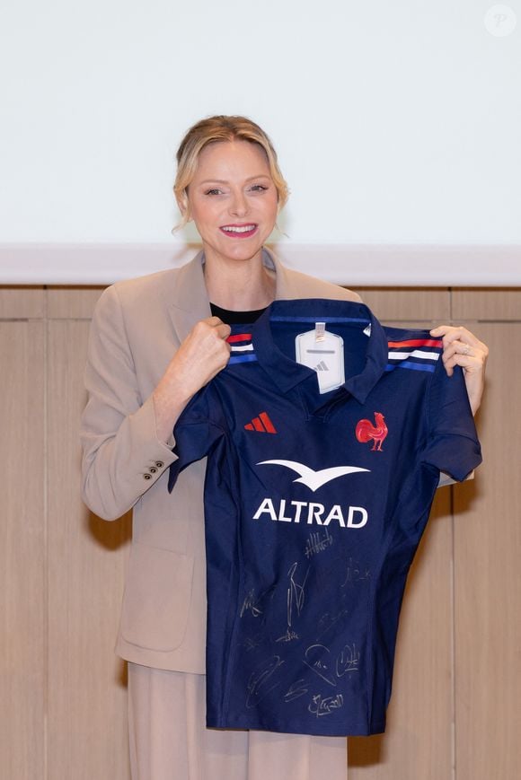 La princesse Charlène de Monaco se voit offrir un maillot dédicacé par les joueurs du XV de France de rugby, vainqueurs du tournoi des 6 nations 2025, des mains de William Servat, l'entraîneur du XV de France - La princesse C.de Monaco, en compagnie de son frère G.Wittstock, participe à la remise des prix de la "Journée du respect" au collège Charles III à Monaco, le 29 avril 2025. © Olivier Huitel / Pool Monaco / Bestimage