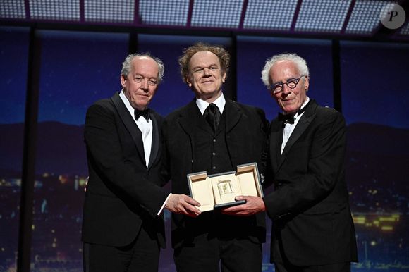 (G-R) Le co-producteur belge Luc Dardenne, l'acteur américain John C. Reilly et le co-producteur belge Jean-Pierre Dardenne s'expriment sur scène après avoir remporté le prix du meilleur scénario pour le film "Jeunes Meres" (The Young Mother's Home) lors de la cérémonie de clôture de la 78e édition du Festival de Cannes à Cannes, France, le 24 mai 2025. Photo de David Niviere/ABACAPRESS.COM