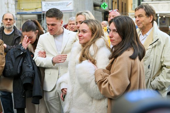 Céline Olive (fille de E.Leclercq), sa fille Ondine (petite-fille de E.Leclercq) et son fils Benjamin costume crème (petit-fils de E.Leclercq) avec le prêtre à la sortie des obsèques d'Evelyne Leclercq en la cathédrale Sainte-Réparate de Nice, France, le 13 janvier 2026. Une tenue blanche ou claire est souhaitée pour la cérémonie. Ni fleurs, ni couronnes. Selon la volonté de la défunte Evelyne, des dons en faveur du pôle cancérologie Arnault Tzanck pourront être effectués par chèque à l'ordre de FDD AAT ou via un lien numérique HelloAsso - Campagne de dons, Institut du Cancer de Mougins. © Bruno Bebert/Bestimage