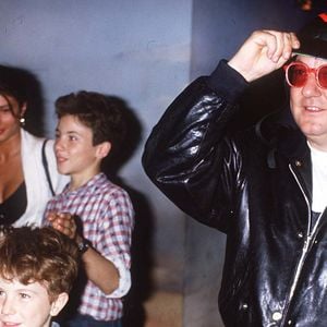 France, 29 juin 1985. Coluche et son amie à la sortie de l’émission "Champs-Élysées" avec ses fils Romain et Marius. (Photo : AGENCE / BESTIMAGE)