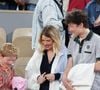 Roman et Aliocha Haroche voient Carlos Alcaraz dédicacer leurs casquettes sous le regard de leurs parents, Mélanie Thierry et son compagnon Raphaël - Les célébrités dans les tribunes des Internationaux de France de tennis de Roland Garros 2024 à Paris, le 29 mai 2024.  © Jacovides / Moreau / Bestimage